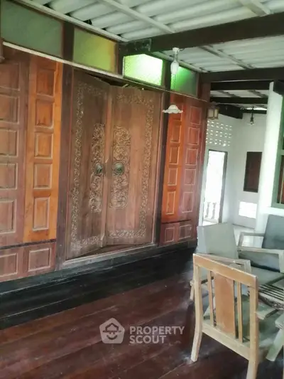 Charming wooden interior with ornate doors and cozy seating area, perfect for a rustic home ambiance.
