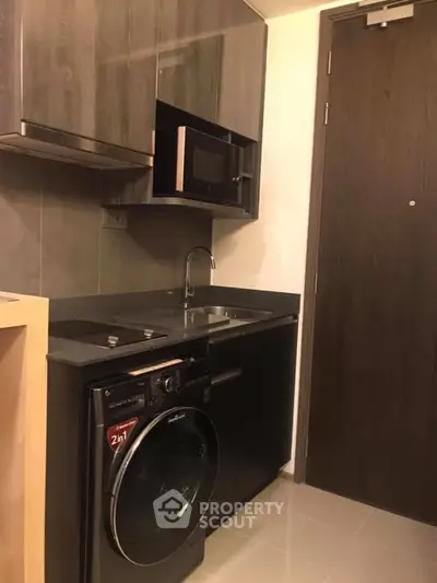 Modern compact kitchen with sleek appliances and dark wood cabinetry