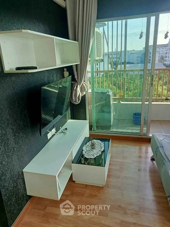 Modern living room with balcony view, featuring sleek furniture and natural light.