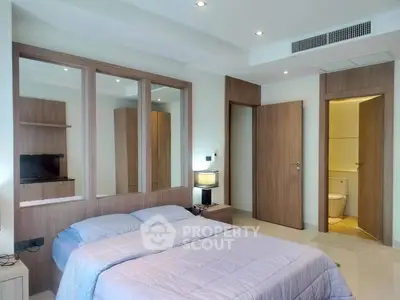 Modern bedroom with ensuite bathroom and sleek wooden finishes.