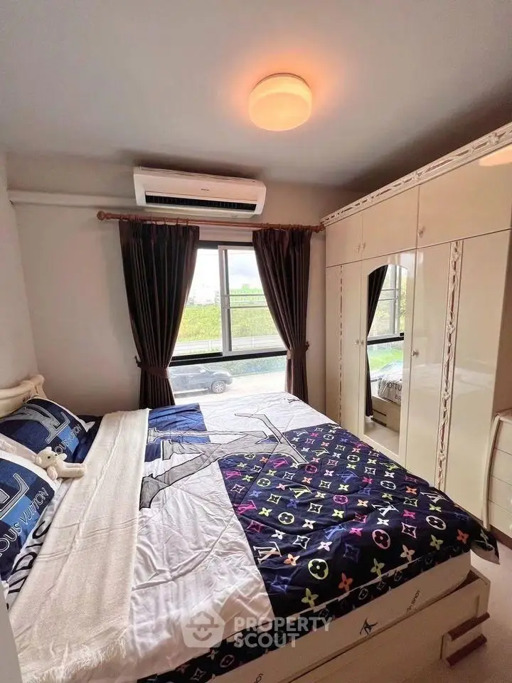 Cozy bedroom with stylish decor and ample natural light, featuring built-in wardrobe and air conditioning.