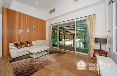 Spacious living room with modern decor and large sliding glass doors opening to balcony.