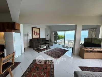 Spacious living room with ocean view, modern furniture, and open layout in luxury apartment.