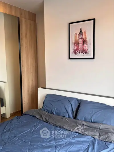 Cozy bedroom with modern decor and stylish wardrobe, featuring a London-themed artwork above the bed.