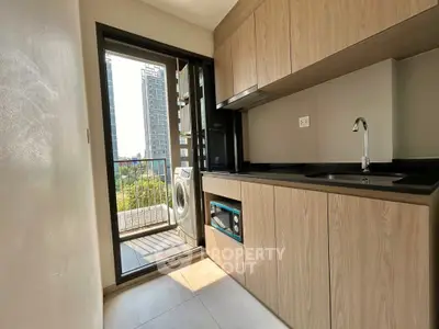 Modern kitchen with wooden cabinets and balcony view in a high-rise apartment