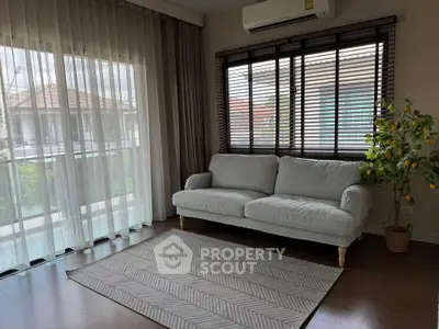 Spacious living room with large windows and modern decor in a stylish home.