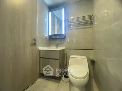 Modern bathroom with sleek fixtures and illuminated mirror in a contemporary apartment.
