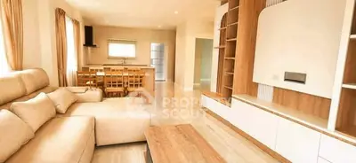 Spacious living room with modern furniture and open dining area in a bright, airy apartment.
