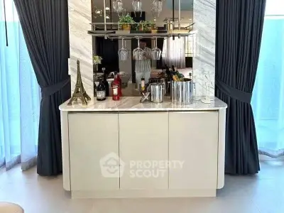 Elegant home bar with marble countertop and wine display in modern living space.