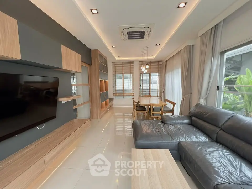 Modern living room with sleek furniture and large windows offering natural light.