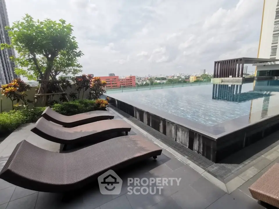 Luxurious rooftop pool with city view and sun loungers, perfect for relaxation.