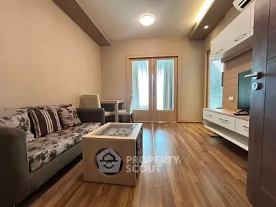 Modern living room with stylish furniture and wooden flooring, perfect for cozy living.