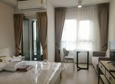 Modern bedroom with balcony access, featuring stylish furniture and natural light.