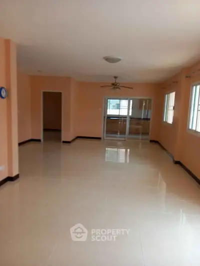 Spacious empty living room with tiled floors and large windows