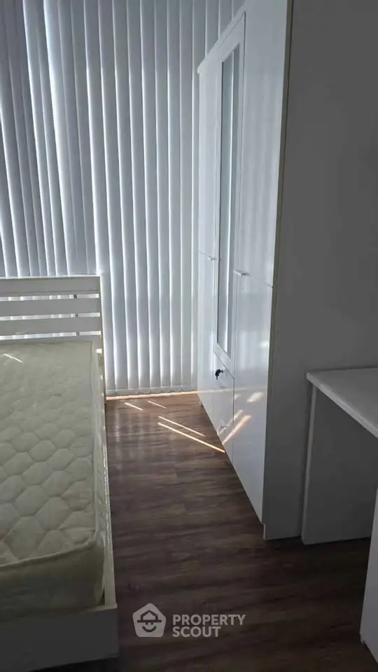 Modern bedroom with sleek white furniture and floor-to-ceiling blinds, perfect for minimalist living.