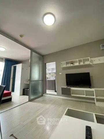 Modern living room with sleek design and TV unit, open to bedroom view.