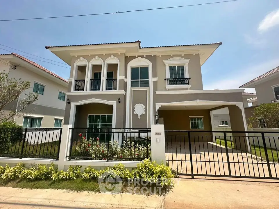Stunning two-story house with elegant facade and gated driveway in a serene neighborhood.