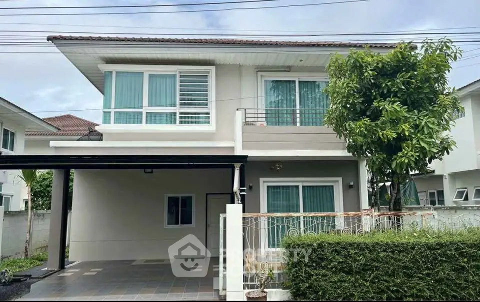 Charming two-story house with modern design and lush greenery, perfect for family living.