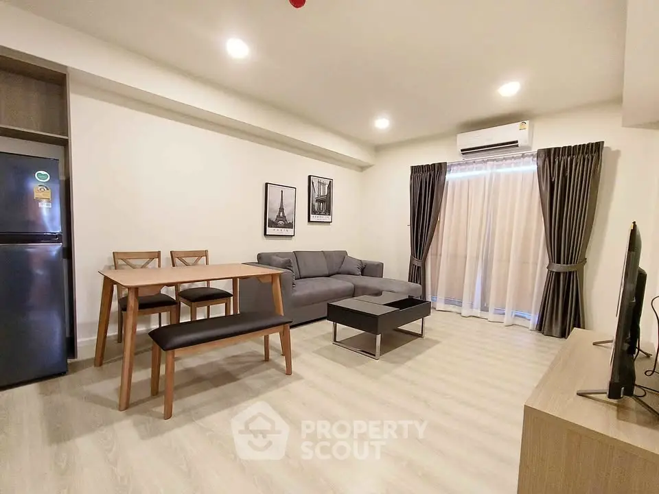 Modern living room with cozy sofa, dining table, and air conditioning in a stylish apartment.