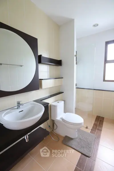 Modern bathroom with sleek fixtures and large mirror in a contemporary home.