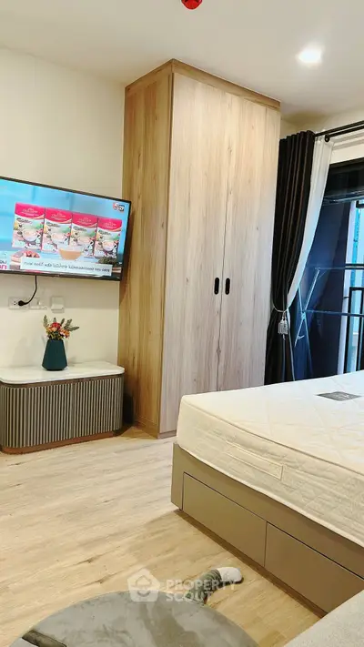 Modern bedroom with wooden wardrobe and wall-mounted TV, featuring elegant decor.