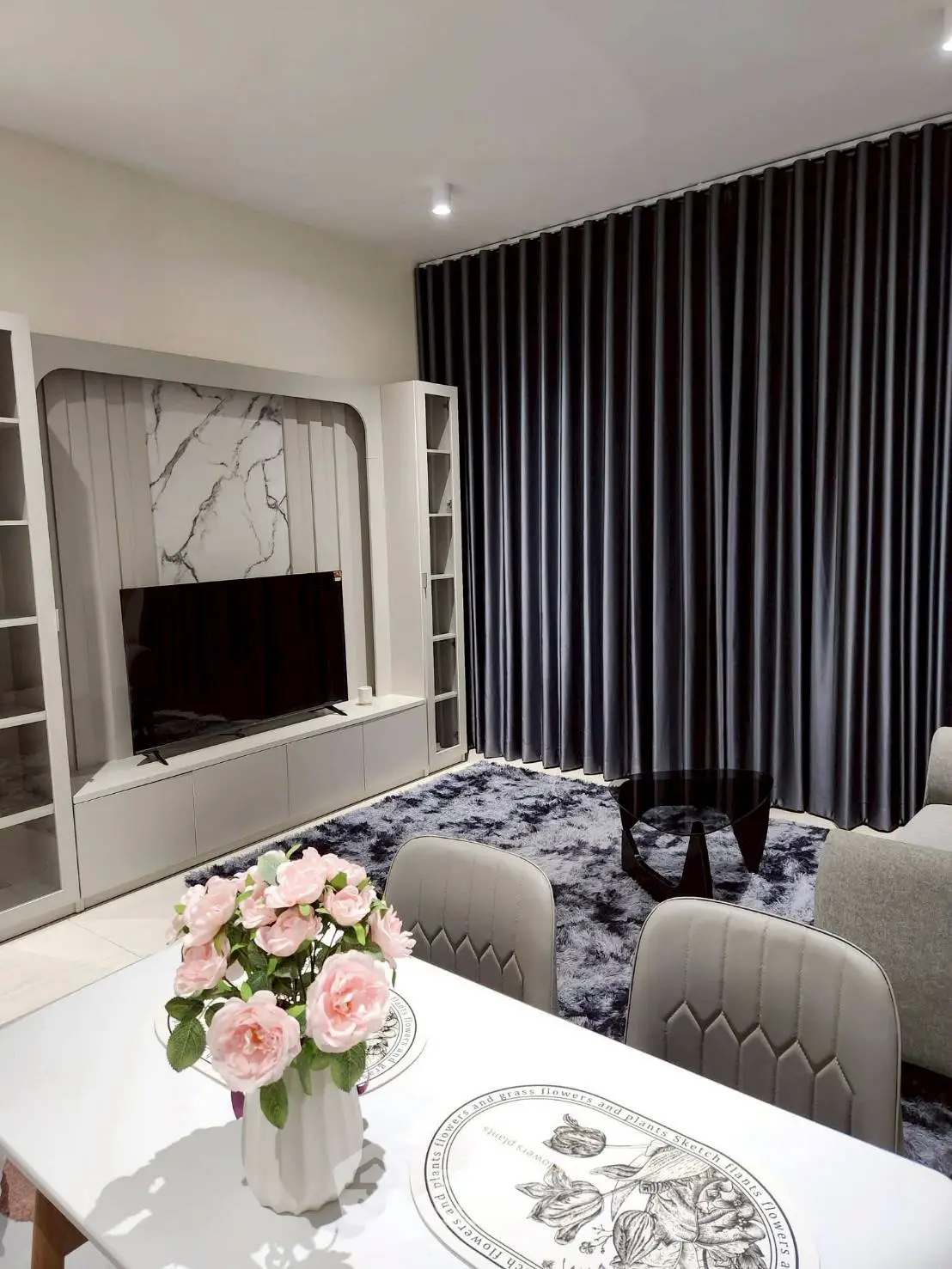 Elegant living room with modern decor, plush carpet, and stylish furniture, perfect for relaxation and entertainment.