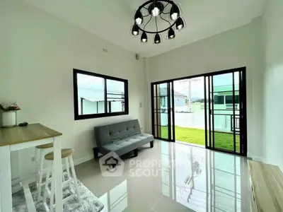 Modern living room with sleek design and large windows offering natural light and garden view.