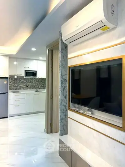 Modern living room with sleek TV setup and stylish kitchen in open layout