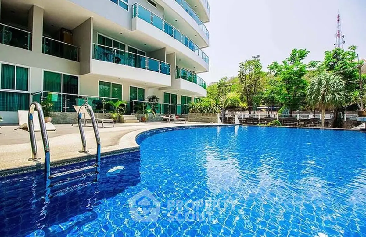 Luxurious apartment complex with a sparkling blue swimming pool and modern balconies.