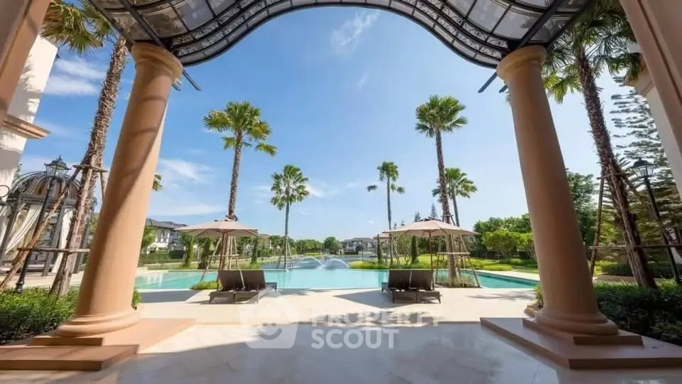 Luxurious poolside view with palm trees and elegant architecture, perfect for relaxation and leisure.