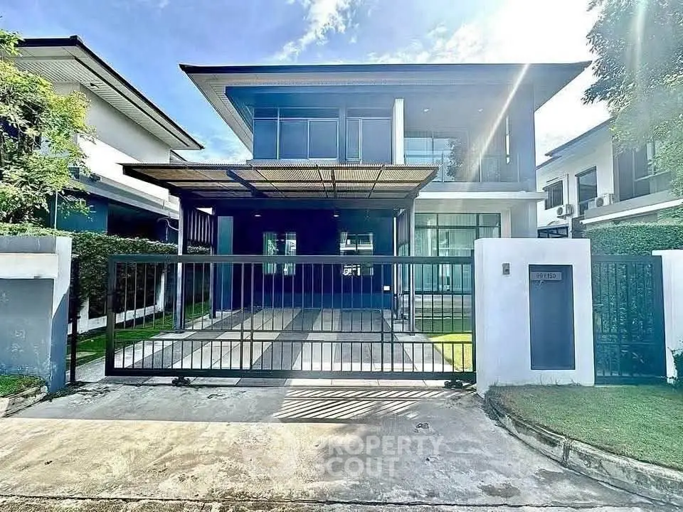 Modern two-story house with sleek design and spacious driveway in a serene neighborhood.