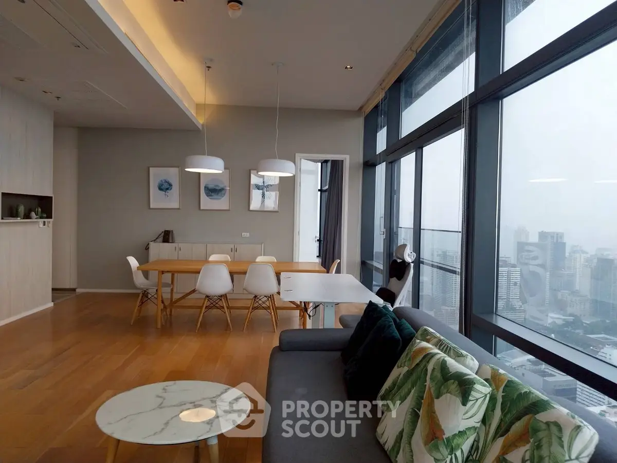 Spacious modern living room with panoramic city view and stylish decor.