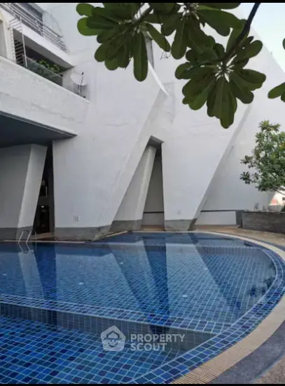 Luxurious modern building with a stunning outdoor pool and unique architectural design.