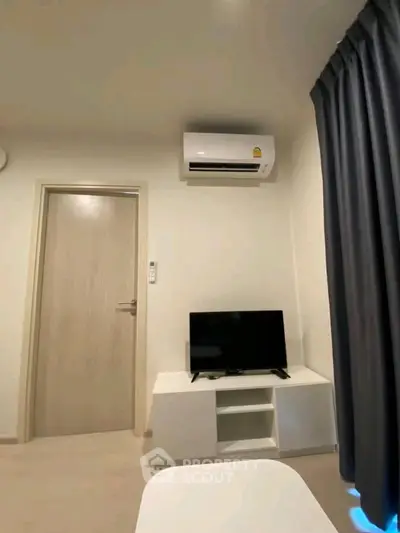 Modern living room with air conditioning and TV setup, perfect for cozy relaxation.