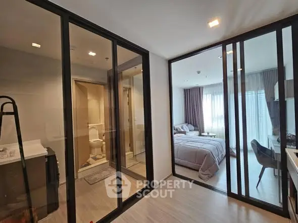 Modern apartment interior with glass partitions and cozy bedroom