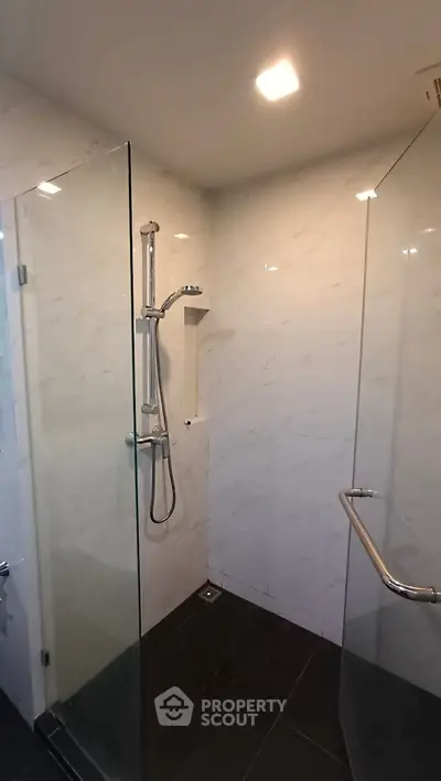 Modern bathroom with glass shower enclosure and sleek fixtures