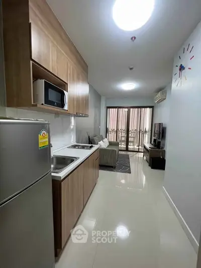Modern apartment kitchen with sleek cabinetry and cozy living area, perfect for urban living.