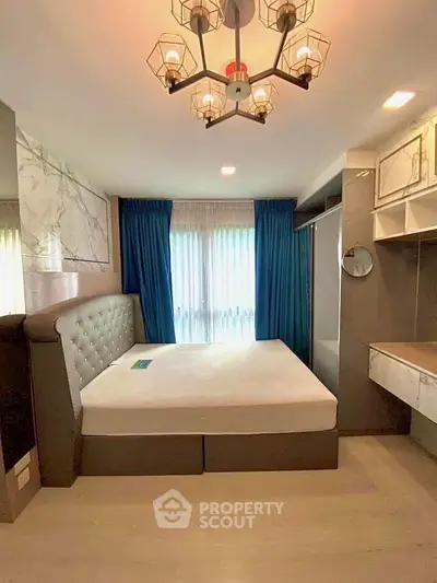 Luxurious bedroom with elegant chandelier and plush bed in modern apartment.