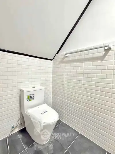 Modern bathroom with sleek white tiles and contemporary toilet design.