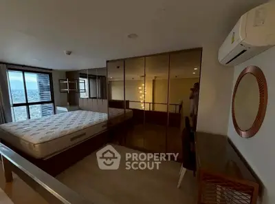 Spacious bedroom with large mirrored wardrobe and city view window
