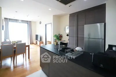 Modern open-layout kitchen and living room with sleek design and natural light.