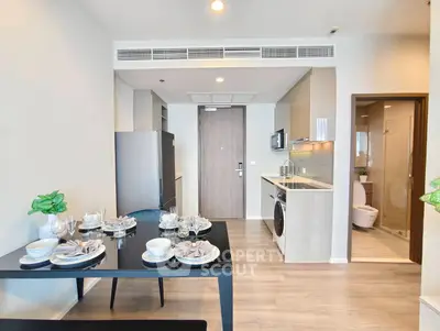 Modern open-layout kitchen with dining area and sleek appliances in a stylish apartment.
