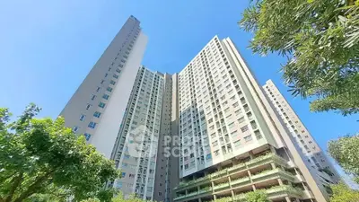 Stunning high-rise residential building with lush greenery and clear blue sky.