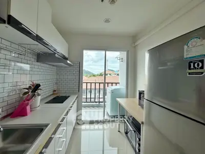 Modern kitchen with sleek cabinets and balcony view