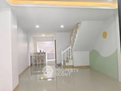Spacious modern living area with sleek staircase and open kitchen layout