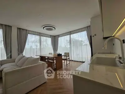 Spacious modern living room with elegant dining area and large windows.