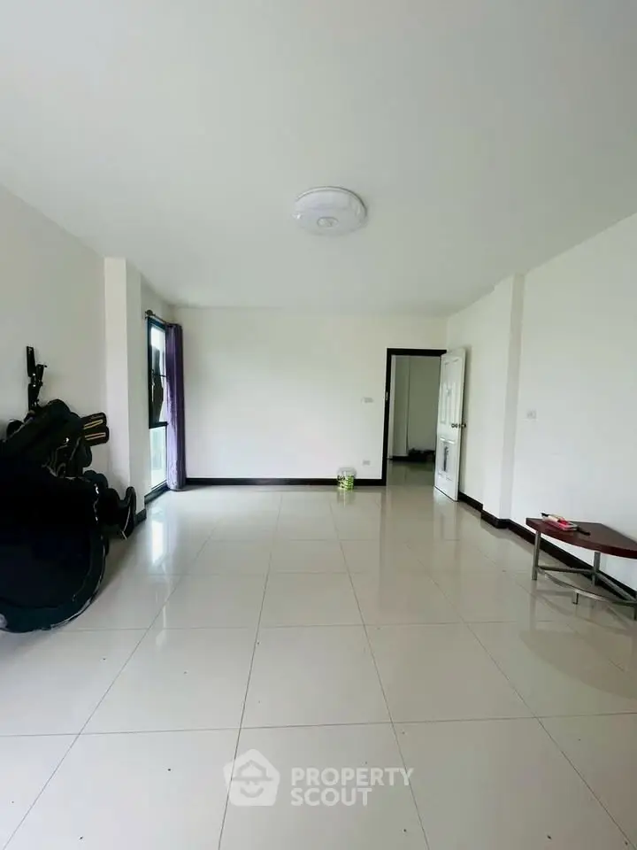 Spacious unfurnished living room with white tiled flooring and natural light