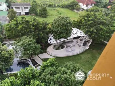 Stunning aerial view of lush garden with modern gazebo and pool in upscale residential area.