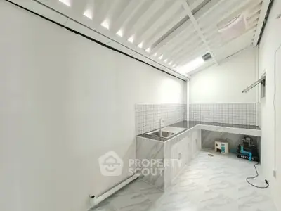 Modern minimalist kitchen with sleek tile backsplash and ample counter space.