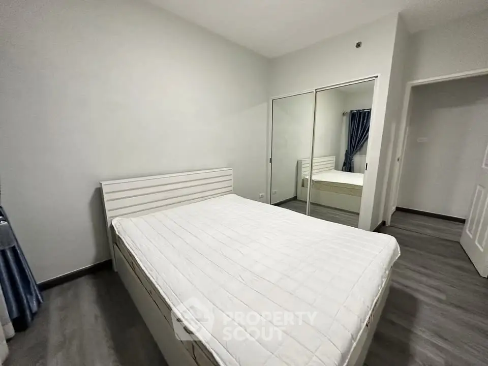 Spacious bedroom with mirrored closet and modern decor